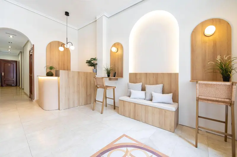 Un espace d'accueil lumineux avec un comptoir et des assises en bois.
