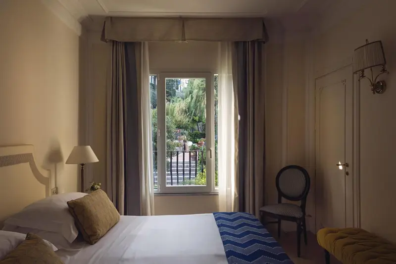 Une chambre lumineuse avec un lit et une vue sur un jardin.