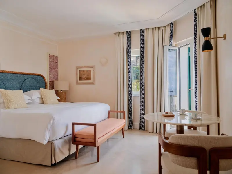 Une chambre lumineuse avec un grand lit et un coin salon.