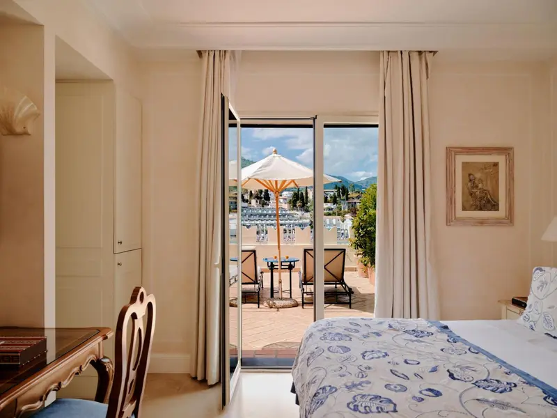 Une chambre lumineuse s'ouvre sur une terrasse avec vue sur la mer.