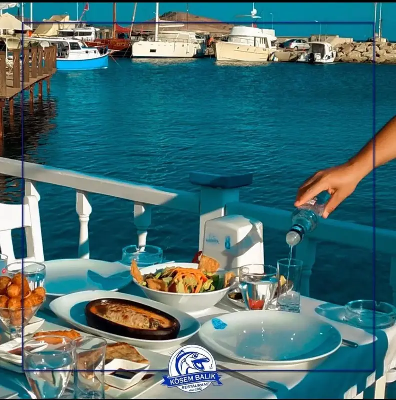 Une table est dressée avec des plats et des boissons en bord de mer.