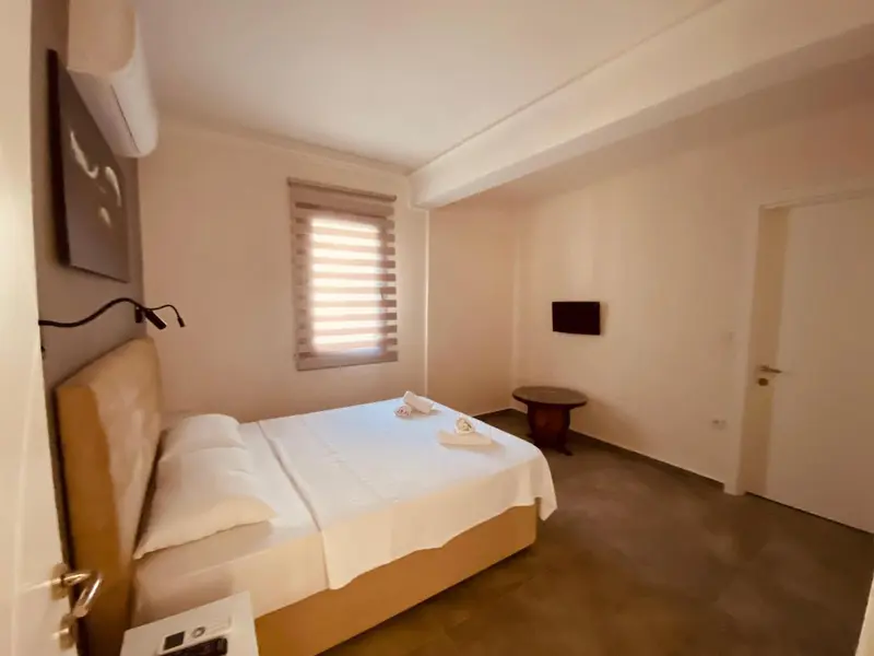 Une chambre lumineuse avec un lit double et une décoration sobre.