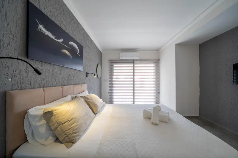 Une chambre avec un grand lit et une décoration sobre.