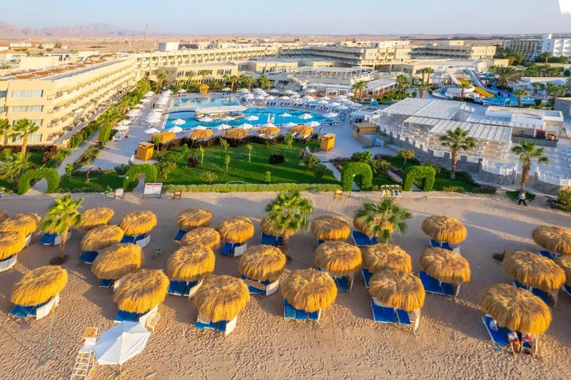 Vue aérienne d'un complexe hôtelier avec piscine et plage.