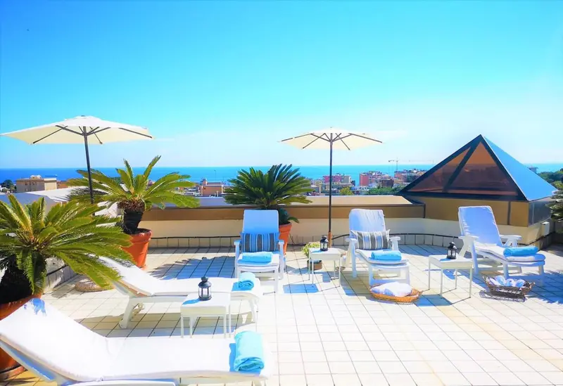 Terrasse aménagée avec chaises longues et vue sur la mer.