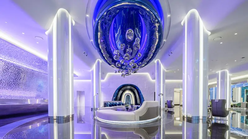 Un hall d'accueil moderne avec un éclairage bleu et des sièges blancs.