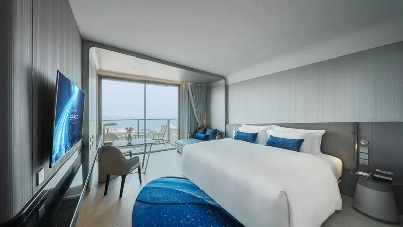 Chambre moderne avec un grand lit et une vue sur la mer.
