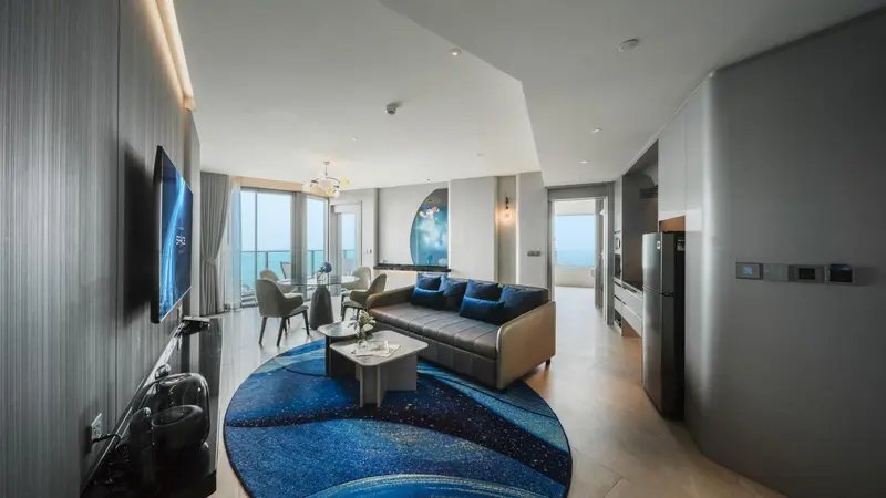 Un salon moderne avec canapé et table basse, donnant sur une vue mer.