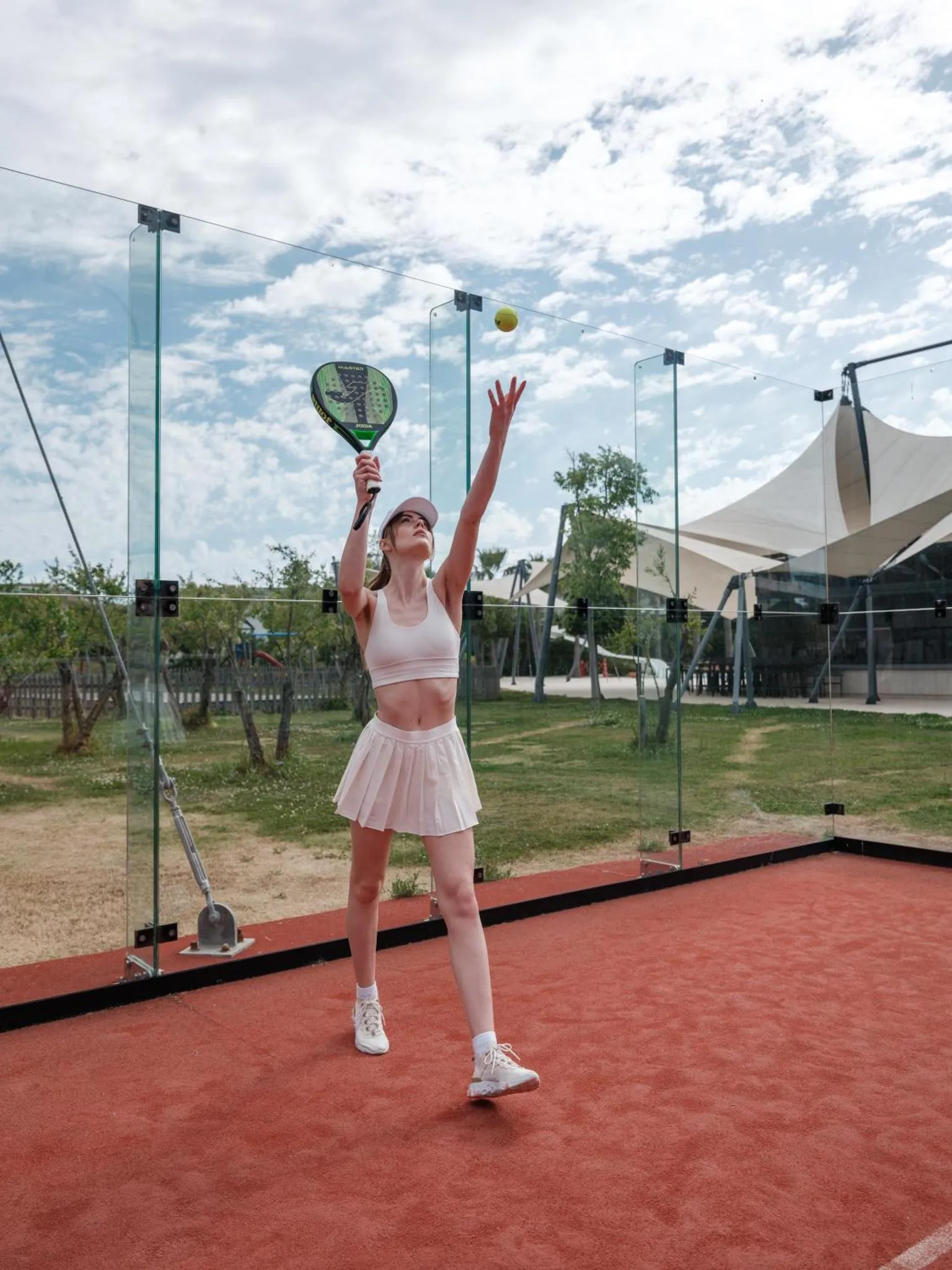 Une femme prépare un service au tennis de table sur une terrasse.