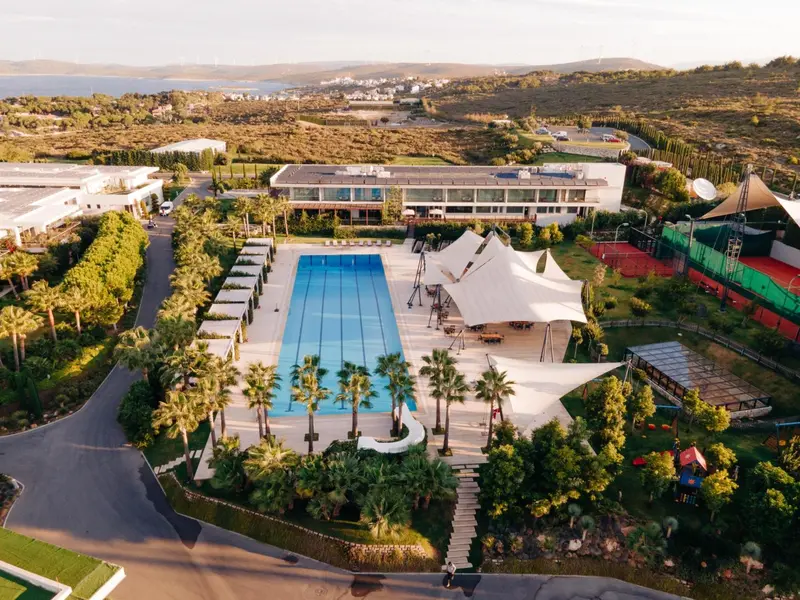 Vue aérienne d'un complexe hôtelier avec piscine et végétation luxuriante.