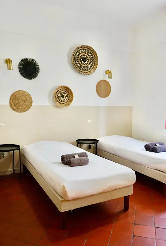 Deux lits simples dans une chambre décorée de rondins en osier.