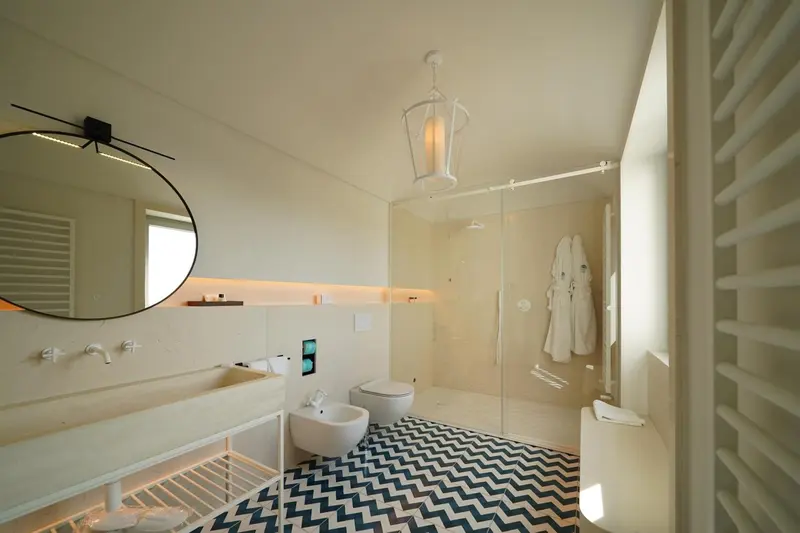 Une salle de bain lumineuse avec douche à l'italienne et vasque moderne.