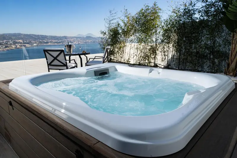 Un jacuzzi extérieur offre une vue dégagée sur la mer et les montagnes.