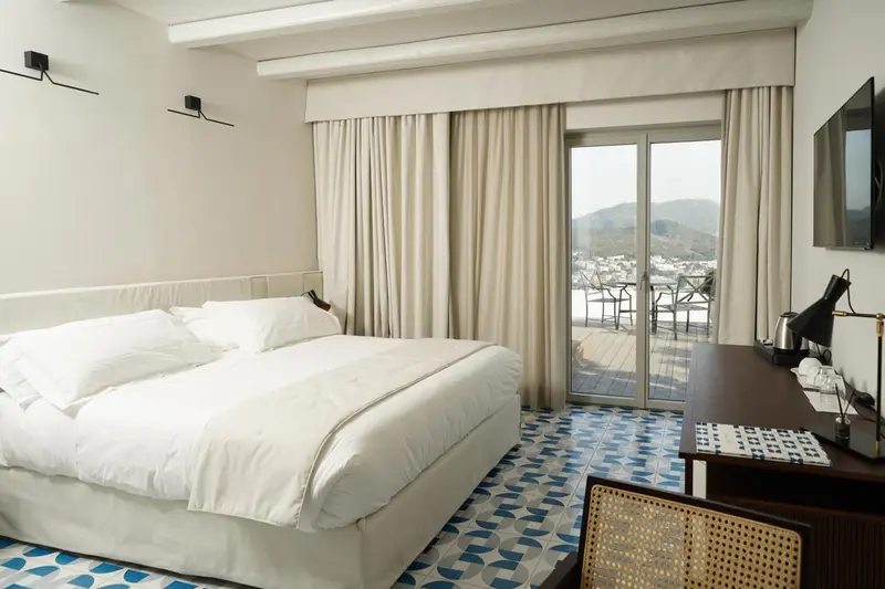 Une chambre lumineuse avec un grand lit et une vue sur le paysage.