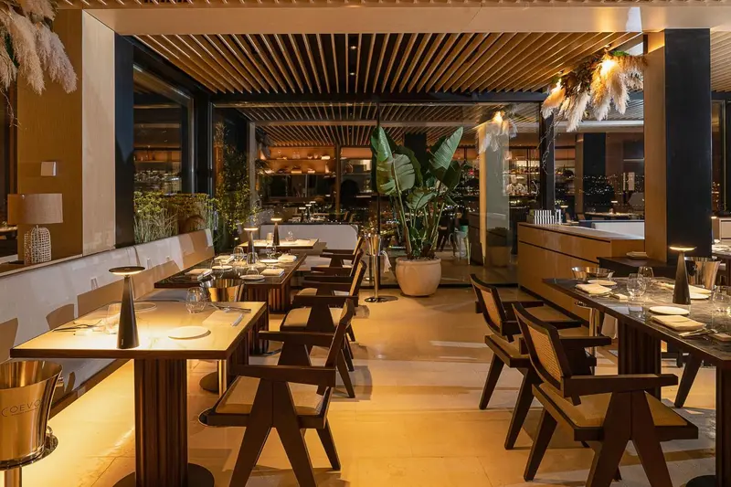 Une salle de restaurant lumineuse avec des tables dressées et une décoration moderne.