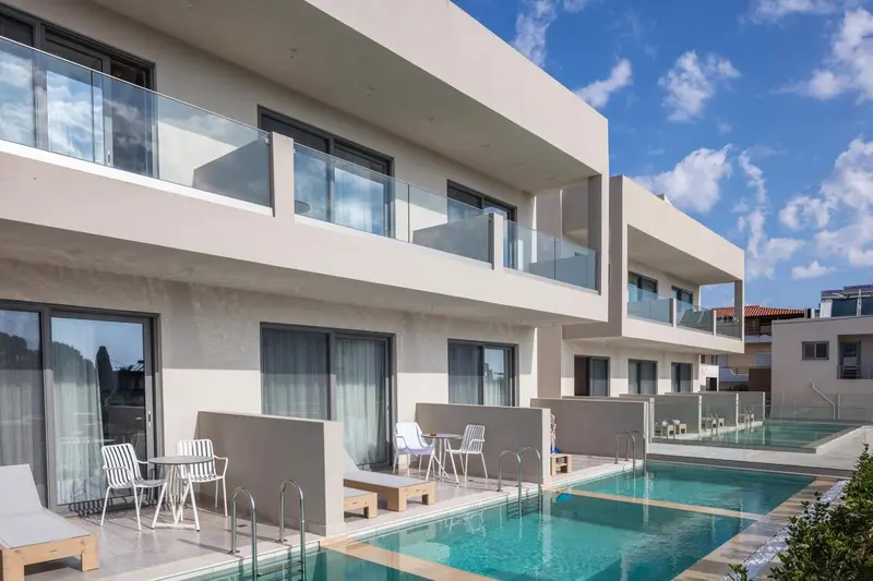 Façade moderne d'un bâtiment avec des balcons et une piscine turquoise.