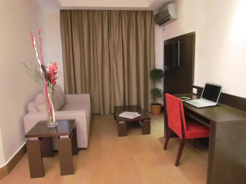 Un espace de séjour lumineux avec un canapé, une table basse et un bureau.