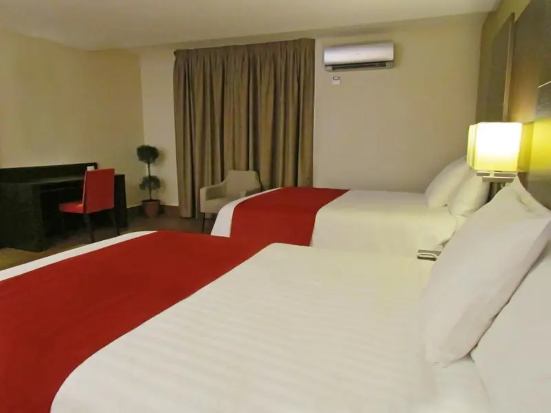 Une chambre d'hôtel avec deux lits et un bureau.