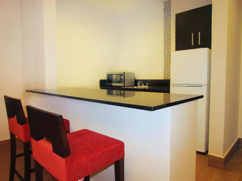 Une kitchenette avec un comptoir et deux tabourets.