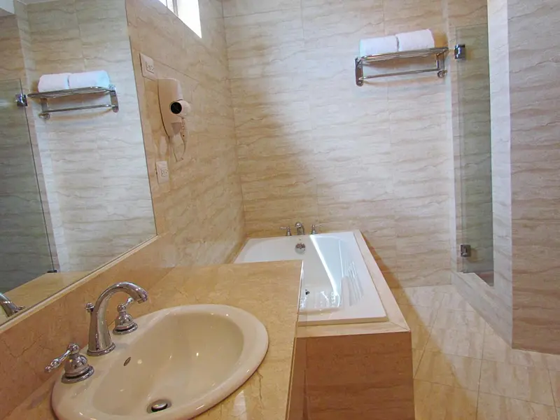 Une salle de bain lumineuse avec baignoire et lavabo.