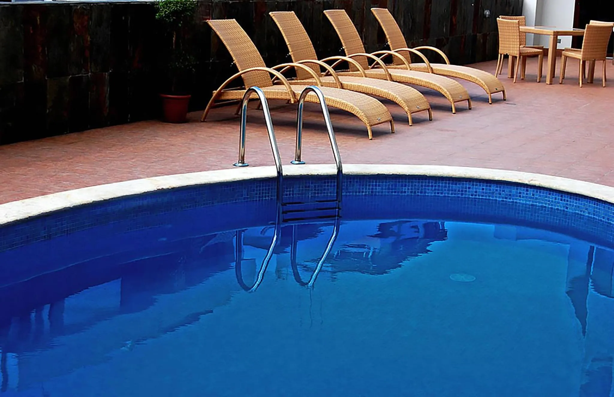 Transats et piscine en extérieur.