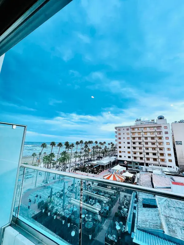 Vue aérienne sur un bâtiment et une plage ensoleillée.