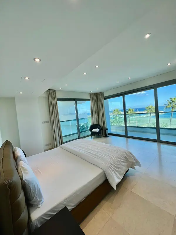 Une chambre lumineuse avec un grand lit et une vue sur la mer.