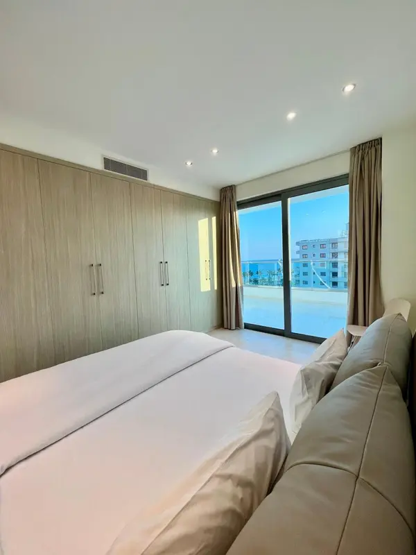 Une chambre lumineuse avec un grand lit et une vue sur la mer.