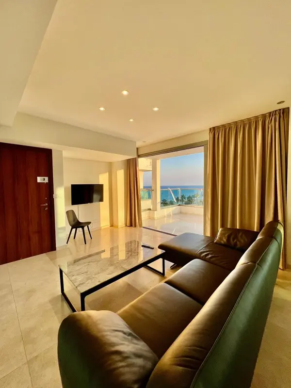 Un salon moderne avec canapé et table basse donne sur une vue mer.