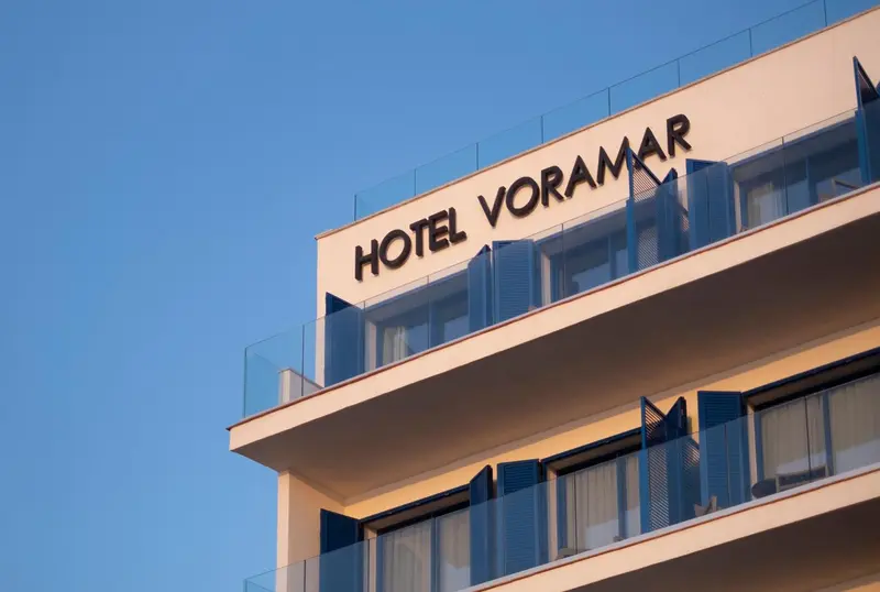 Façade d'un bâtiment moderne avec le nom de l'hôtel en lettres blanches.