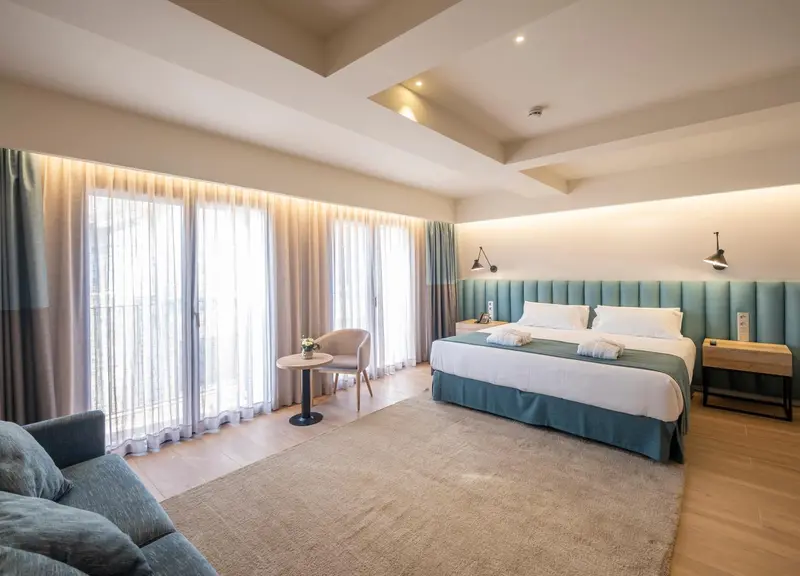 Une chambre lumineuse avec un grand lit et un coin salon.