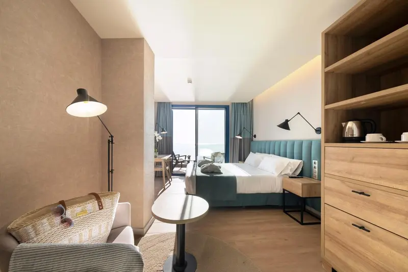 Une chambre lumineuse avec un lit double et un coin salon.