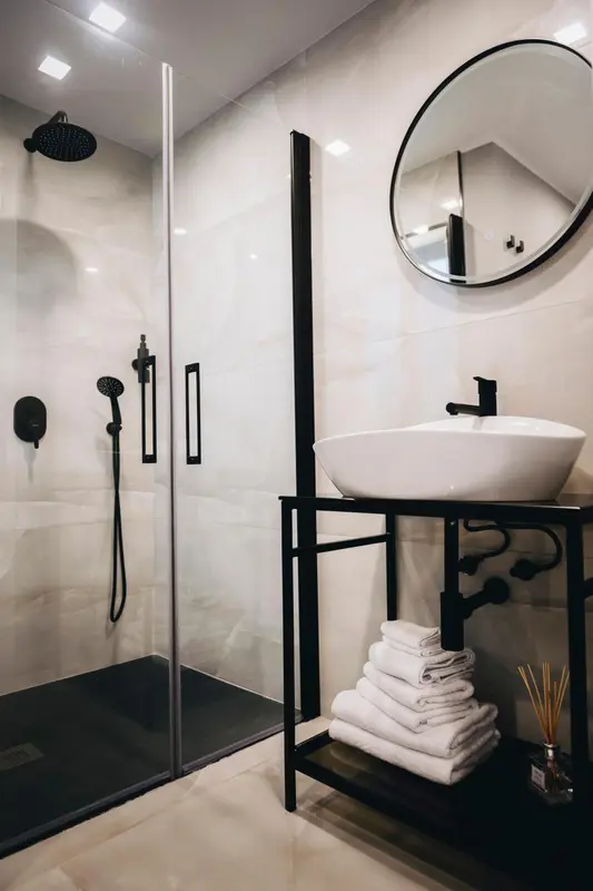 Une salle de bain moderne avec une douche à l'italienne et un lavabo sur pied.