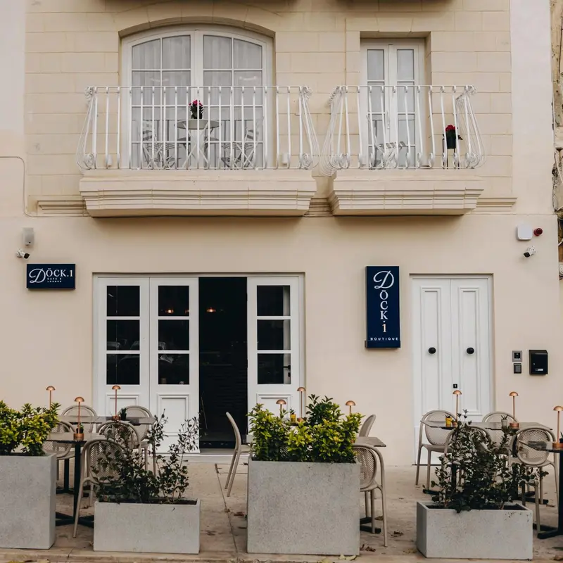 Façade d'un bâtiment avec des balcons en fer forgé et des plantes en pots.