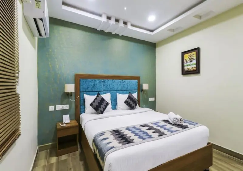 Une chambre lumineuse avec un grand lit et une décoration murale.