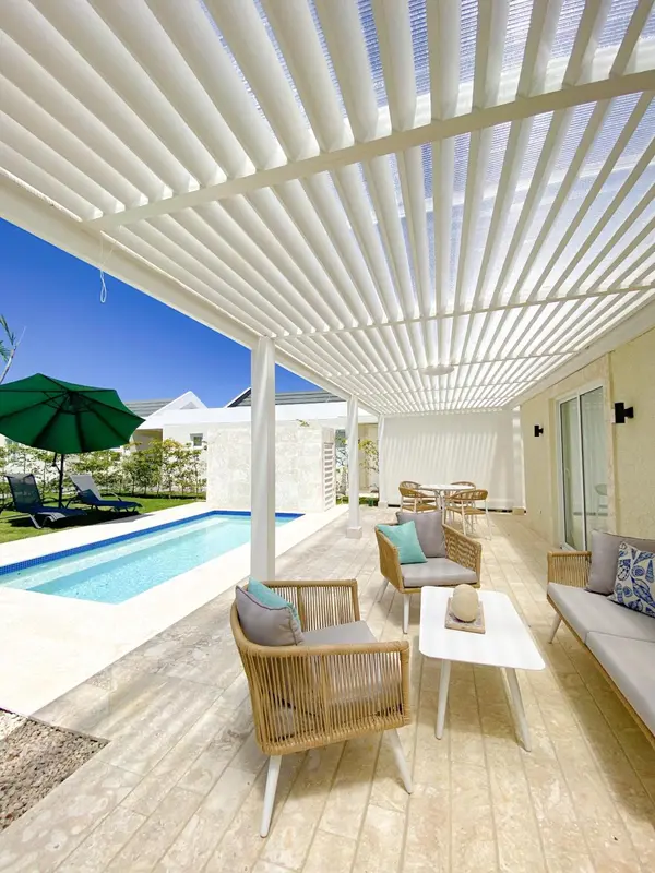 Espace extérieur aménagé avec salon et piscine sous une pergola.