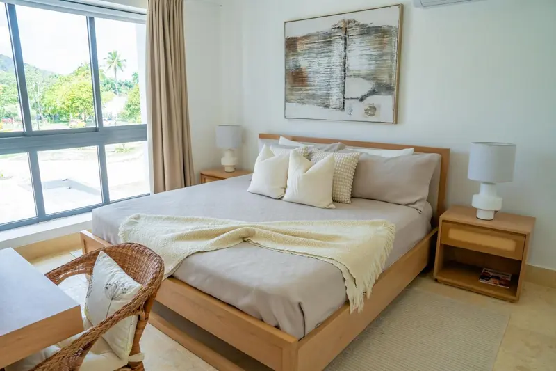 Une chambre lumineuse avec un grand lit et une décoration sobre.
