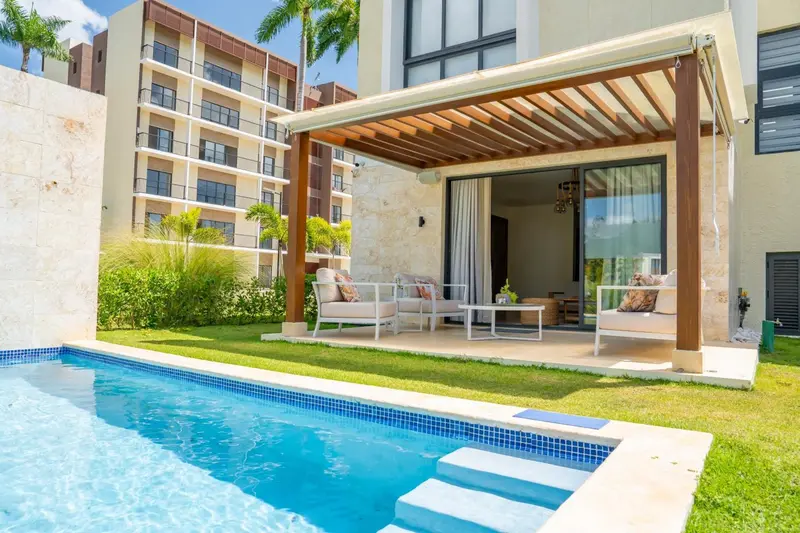 Terrasse aménagée avec salon et piscine privée devant un bâtiment.