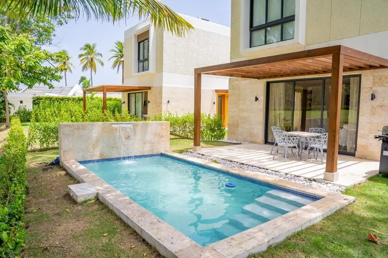 Petite piscine privee devant une residence avec terrasse ombragée.