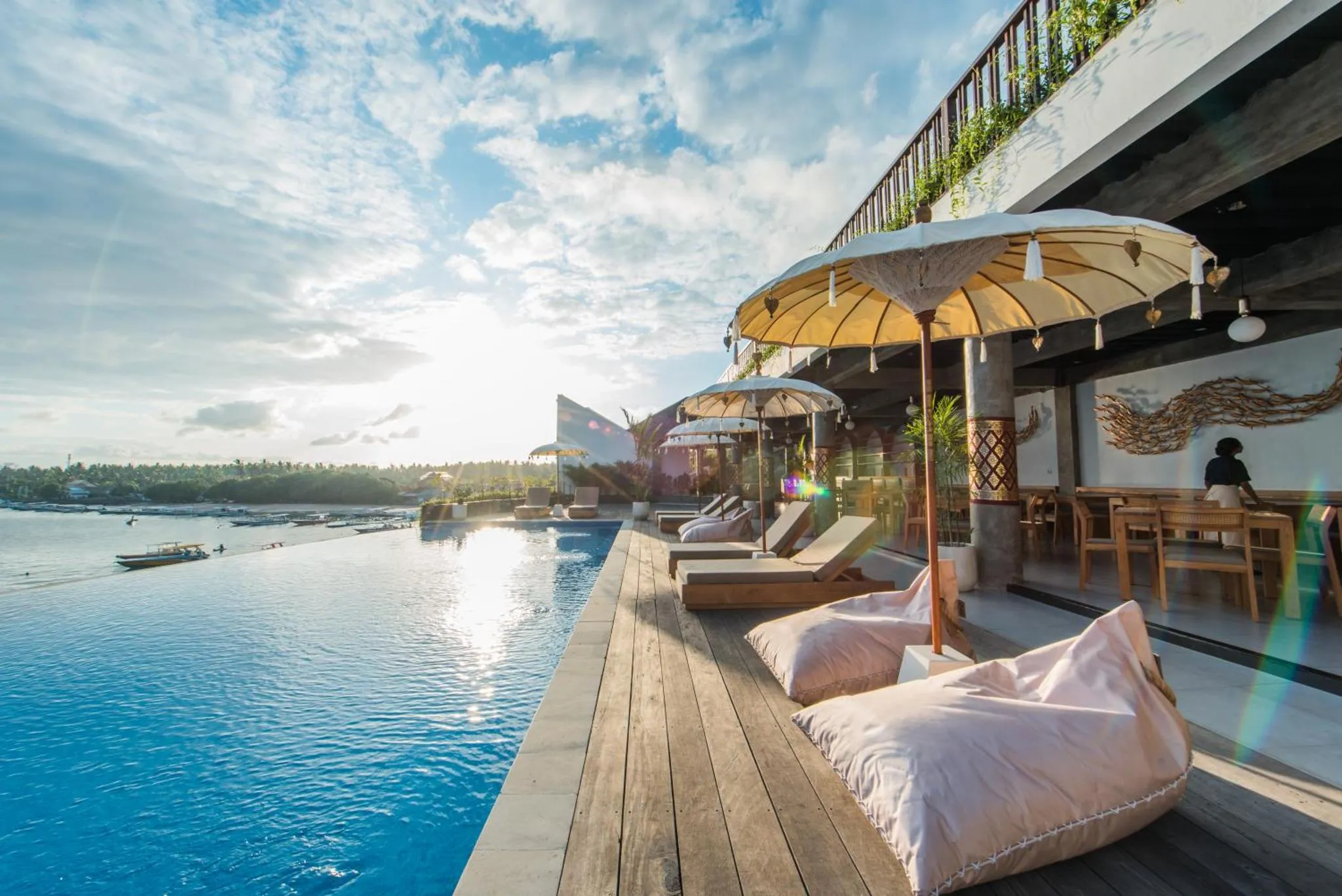 Terrasse avec piscine et mobilier de détente en bord de mer.