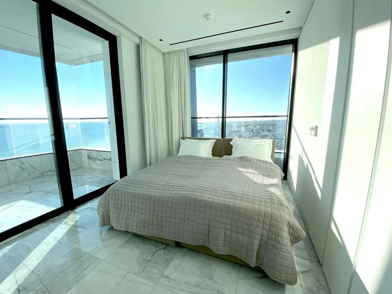 Une chambre lumineuse avec un grand lit et une vue sur la mer.
