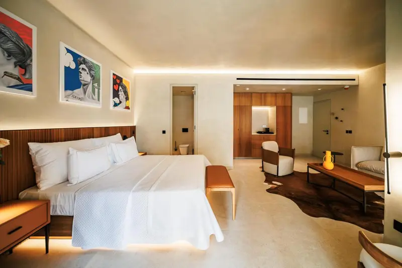Une chambre lumineuse avec un grand lit et un coin salon.