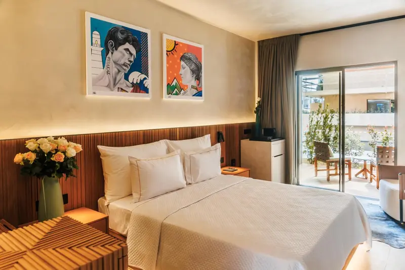 Une chambre lumineuse avec un grand lit et un accès à une terrasse.