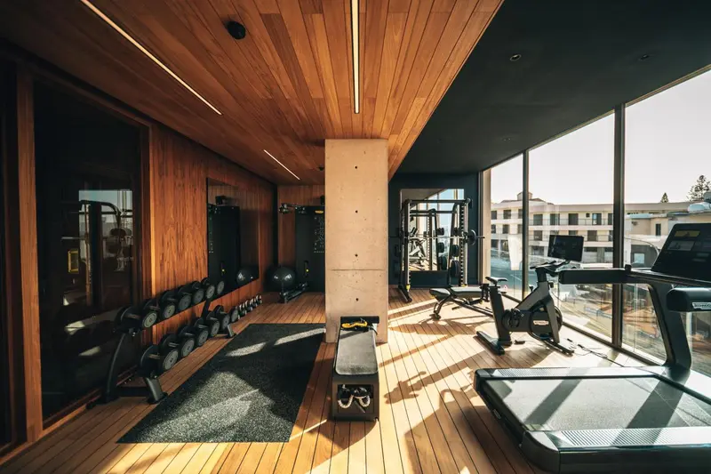 Une salle de sport lumineuse avec des équipements de musculation et des tapis.