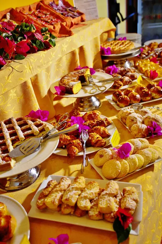 Un buffet propose une grande variété de pâtisseries et de viennoiseries.