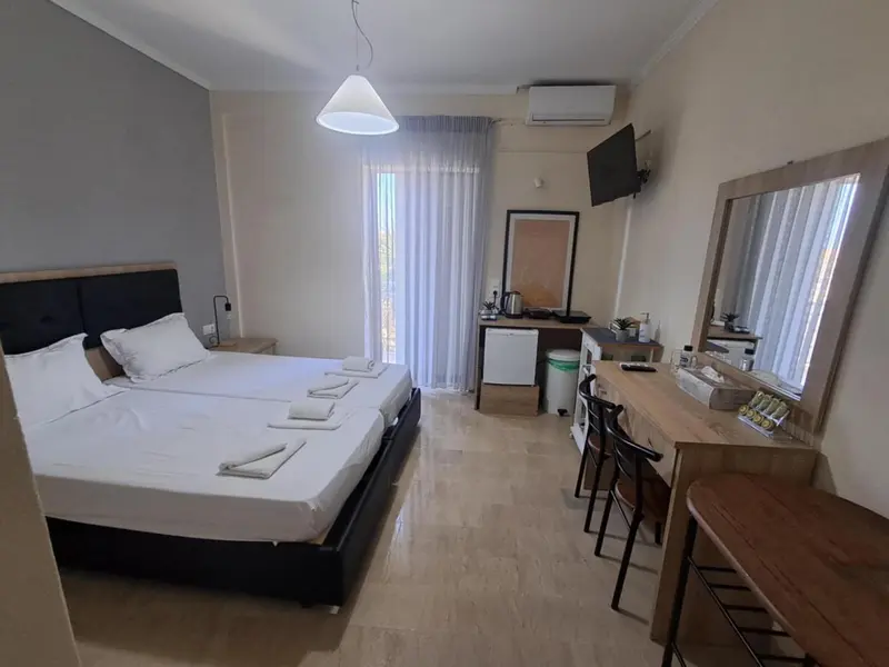 Une chambre lumineuse avec un grand lit et un espace bureau.