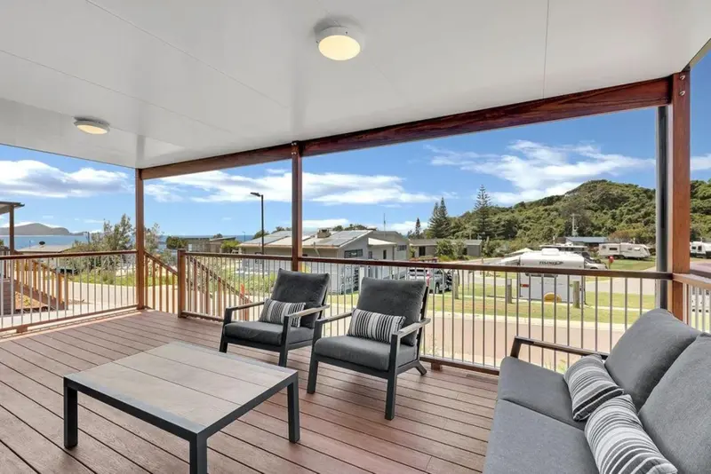 Terrasse aménagée avec salon et vue sur un paysage côtier.