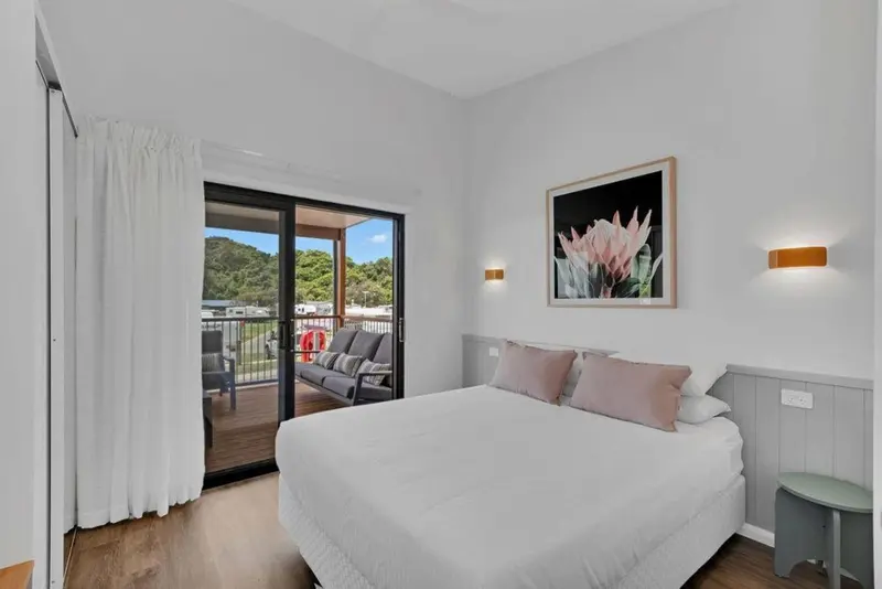 Une chambre lumineuse s'ouvre sur une terrasse avec un coin salon.