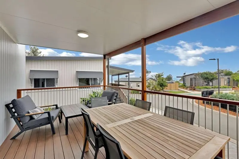 Terrasse aménagée avec mobilier de jardin et vue sur des bâtiments.