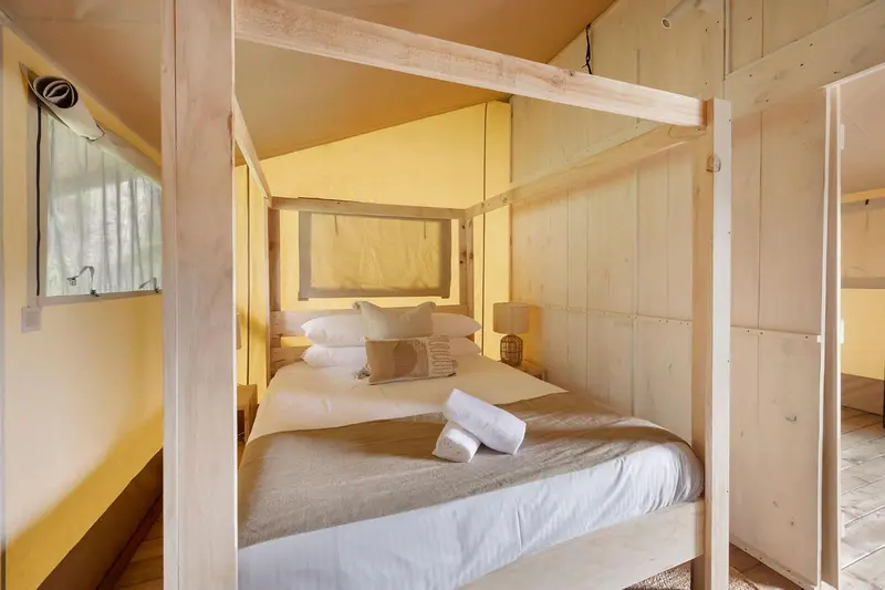 Une chambre lumineuse avec un lit à baldaquin et une décoration sobre.